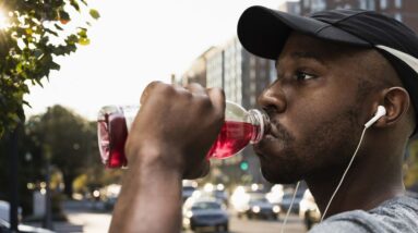 black runner drinking juice in city royalty free image 1684443625