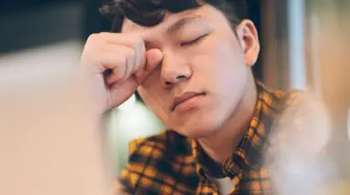 exhausted young man rubbing eyes in cafe royalty free image 1685451233